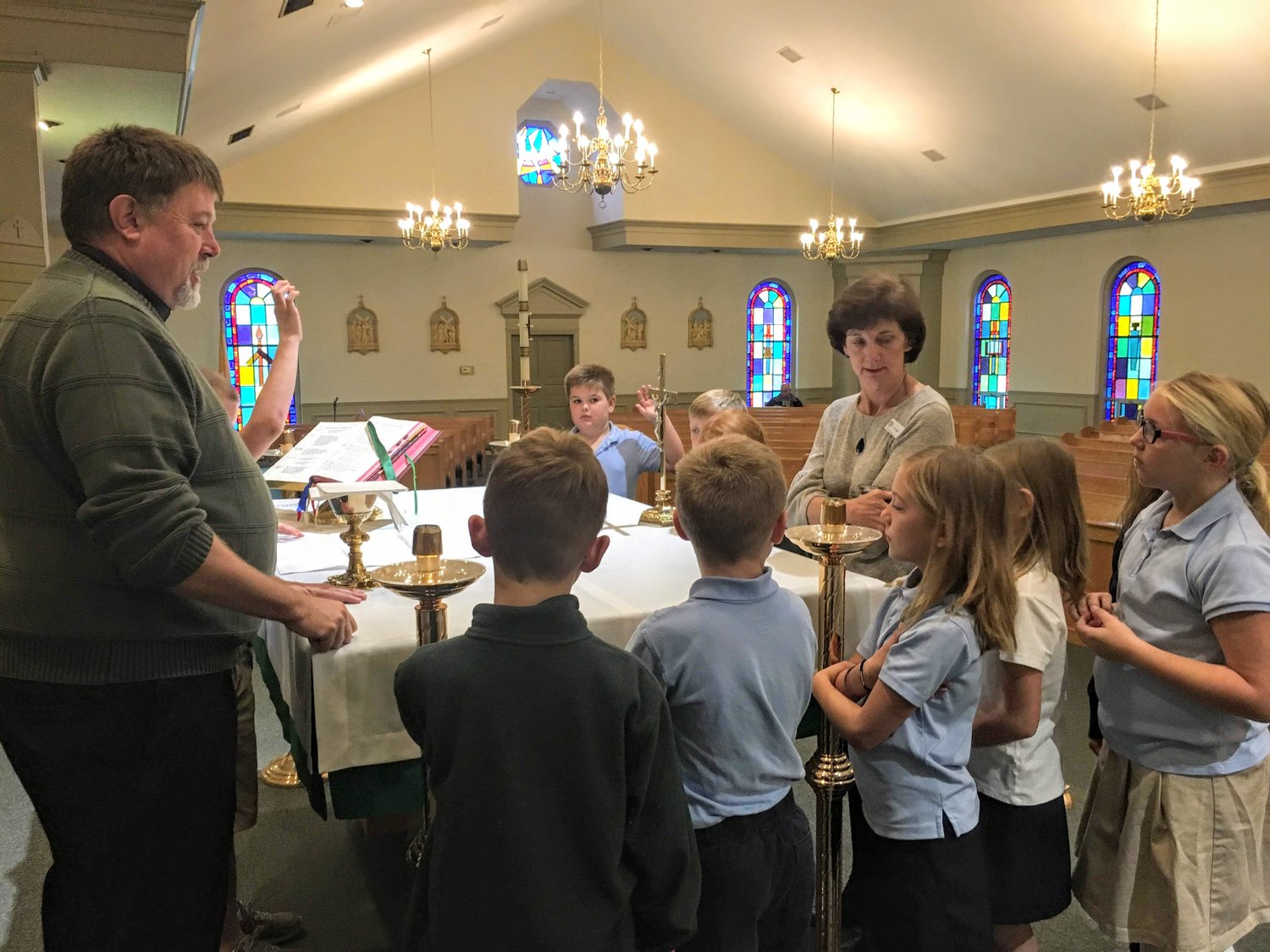 Father William Peckman, pastor of Ss. Peter & Paul parish in Boonville and St. Joseph parish in Fayette, and Ss. Peter & Paul School third-grade teacher Melissa Nagel show her students around the sanctuary during a training for future altar servers.